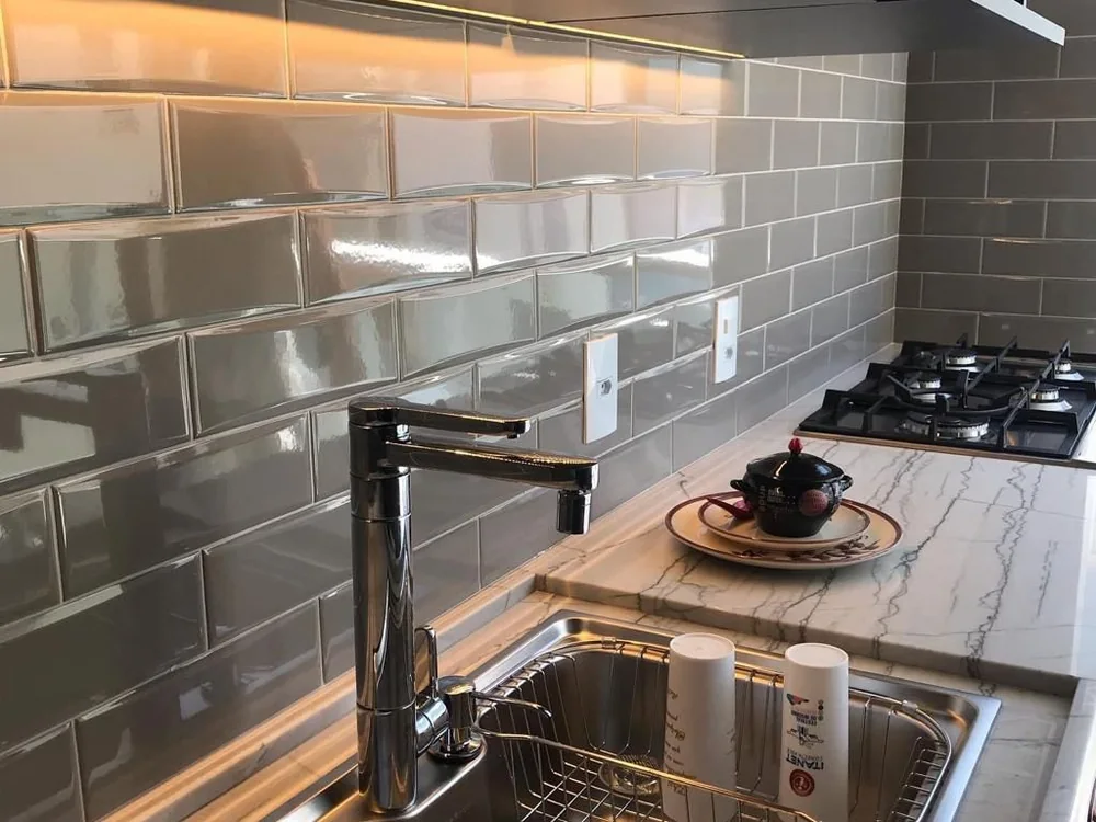 Bancada em mármore com cuba inox e revestimento metalizado