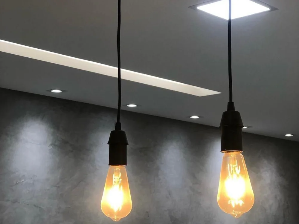 Iluminação pendente sobre parede em cimento queimado