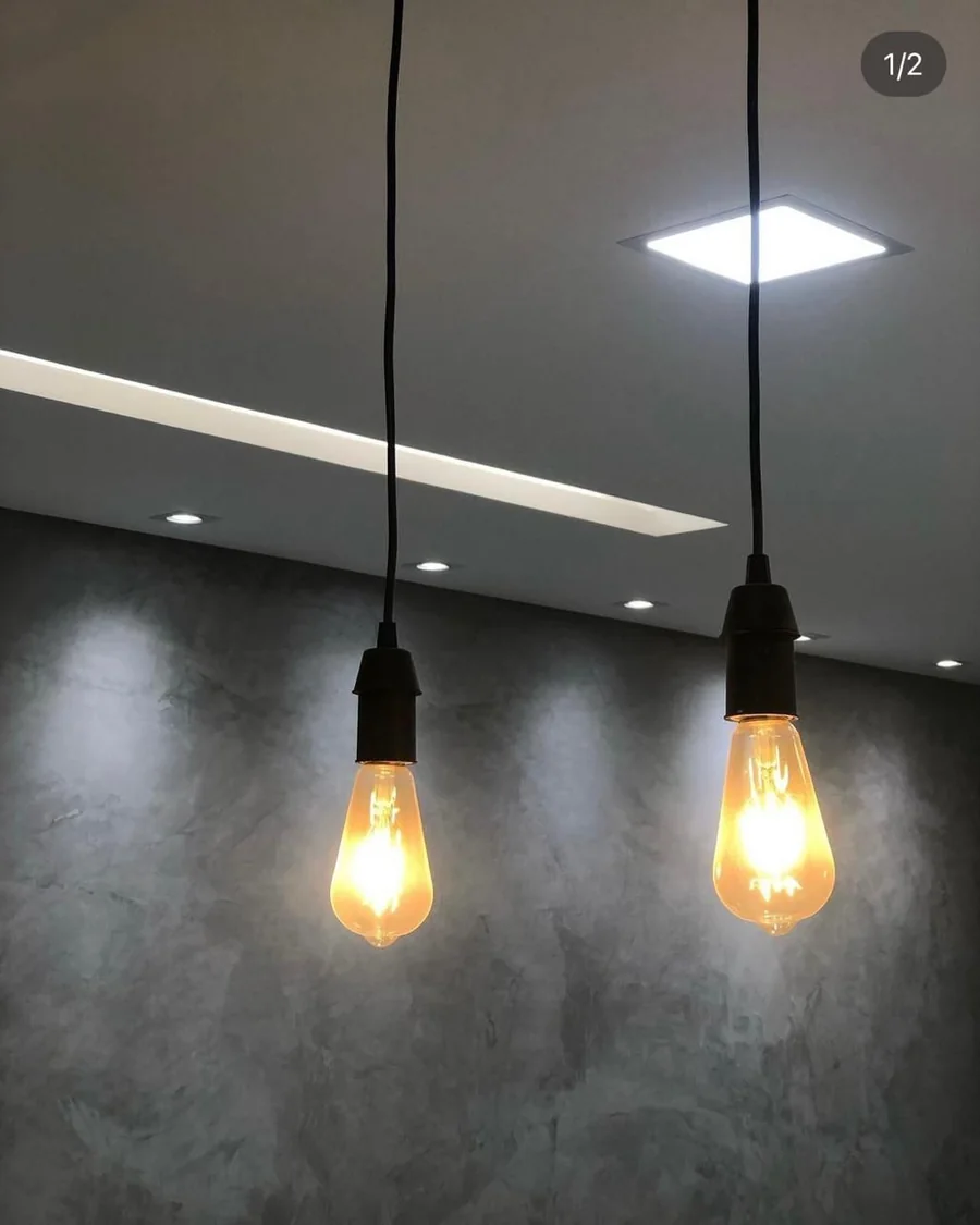 Iluminação pendente sobre parede em cimento queimado